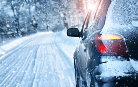 A car driving on an empty snow covered road