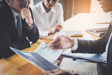 two people speaking to another with documents